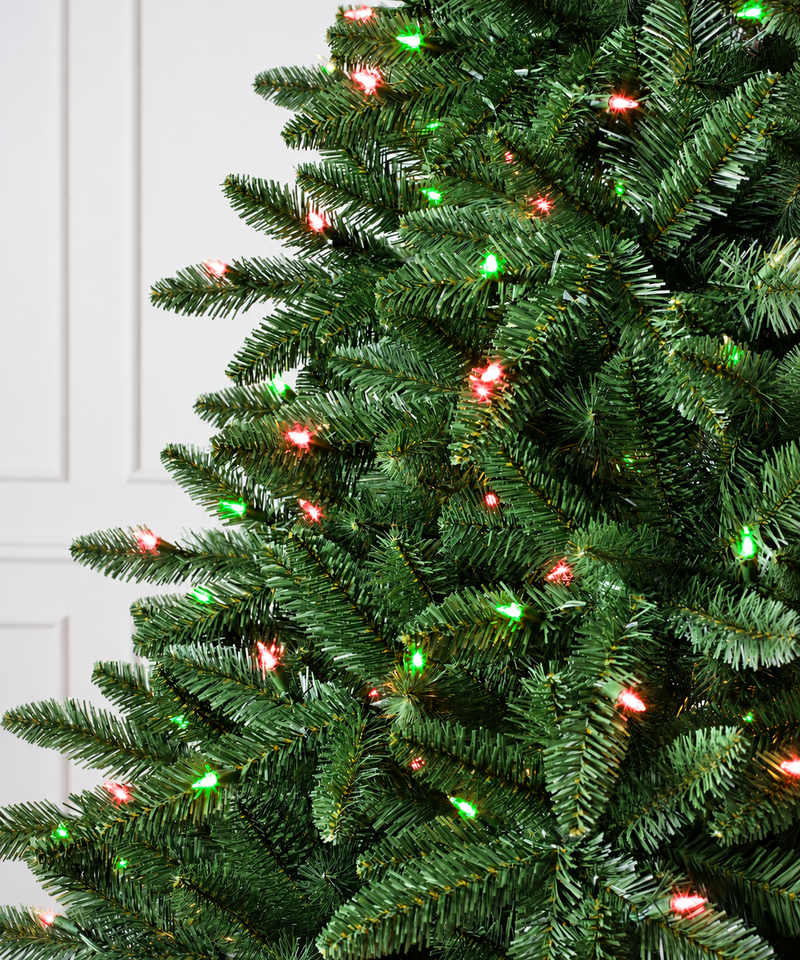 Close-up of green Christmas tree branches with integrated RGB lights